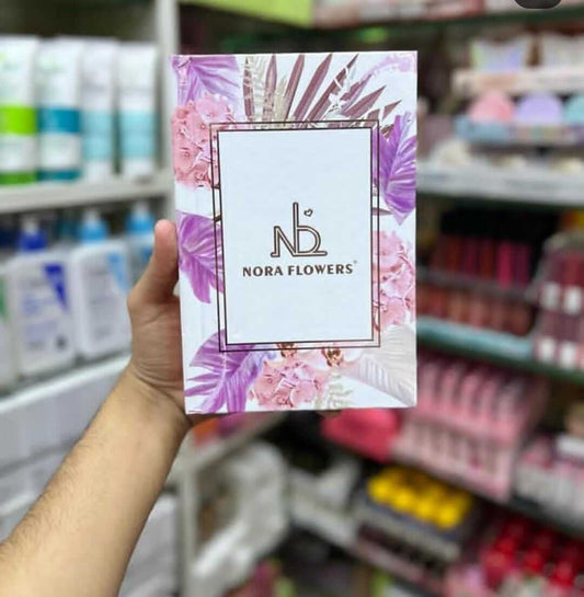Nora Flowers product packaging displayed in a hand, featuring floral design and logo, set against a store background.